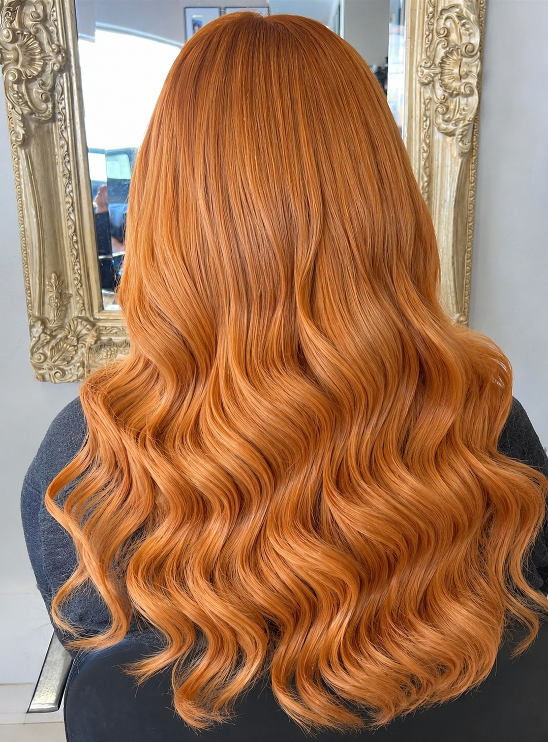 Vibrant copper hair styled in long glossy Hollywood waves